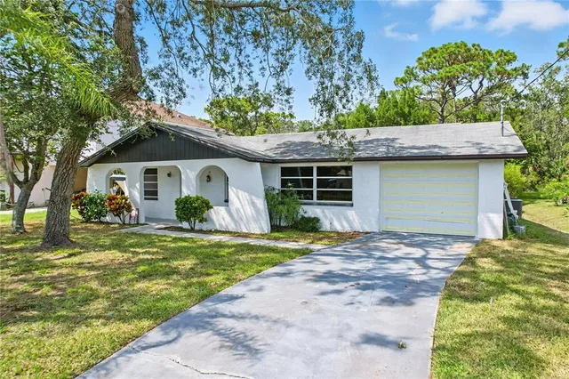 a front view of a house with a garden and trees