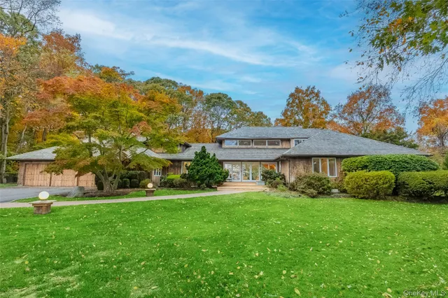 a view of a house with a big yard and large trees