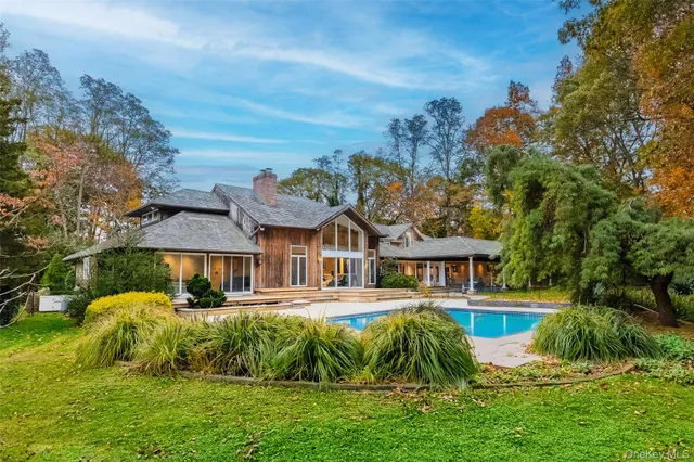a view of a house with pool and sitting area