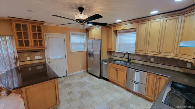 a living room with stainless steel appliances furniture a rug and a view of kitchen