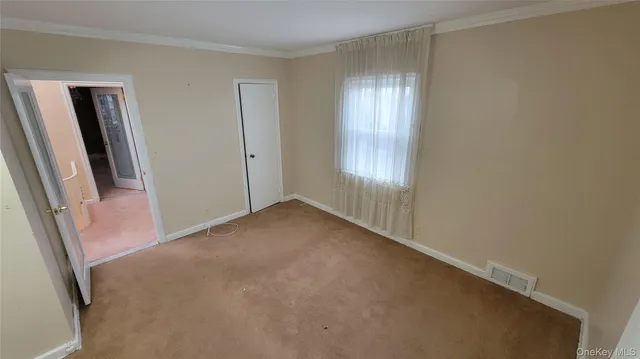 a view of an empty room with a fireplace and a window