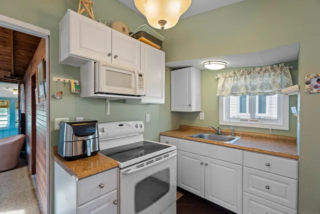 a kitchen with white cabinets and white appliances