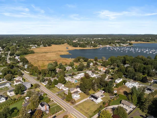 an aerial view of ocean and residential houses with outdoor space