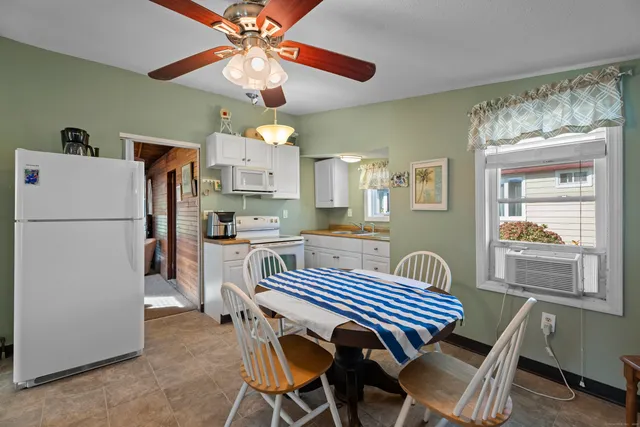 a kitchen with a table chairs refrigerator and cabinets