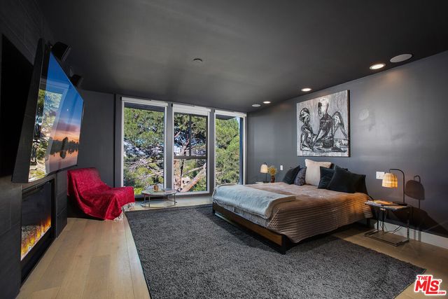 a bedroom with a bed and large windows