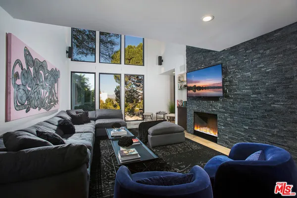 a living room with furniture a flat screen tv and a fireplace