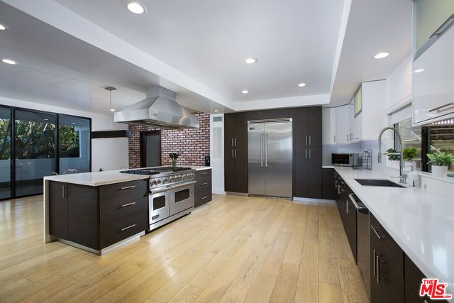 a large kitchen with stainless steel appliances granite countertop a large counter top and a stove
