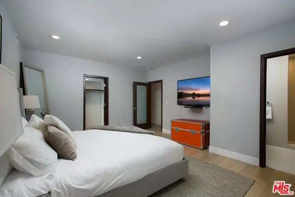 a bedroom with a bed and a large mirror