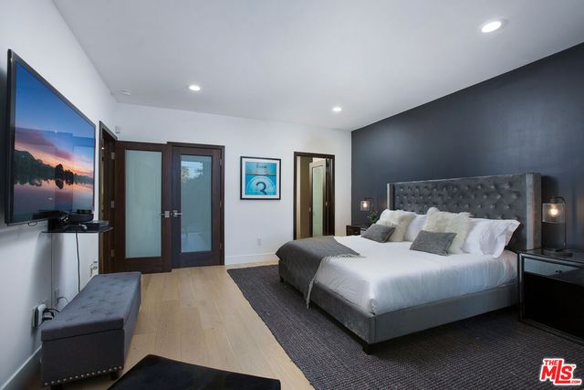 a bedroom with a large bed and a flat screen tv