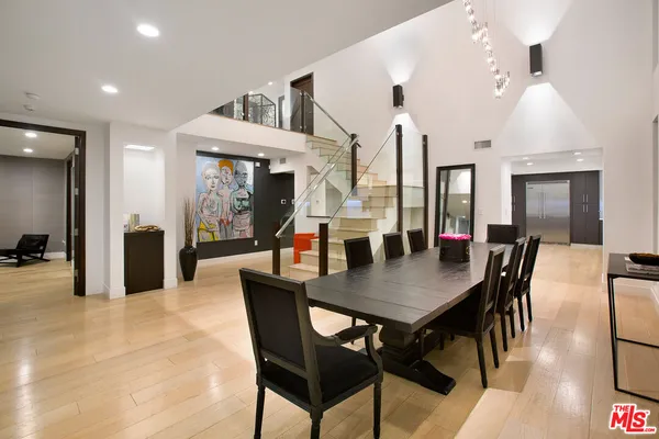 a view of a a dining room and livingroom with furniture wooden floor a chandelier