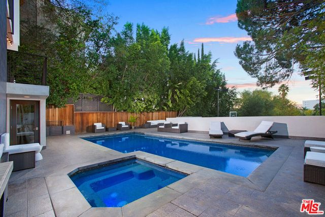 a view of backyard with swimming pool and outdoor seating