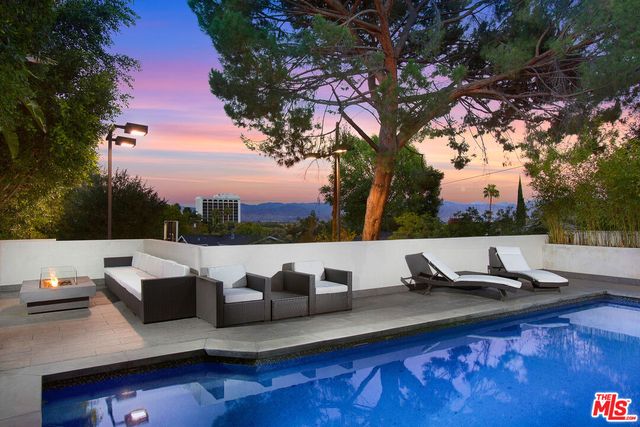 a view of a roof deck with couches and sky view