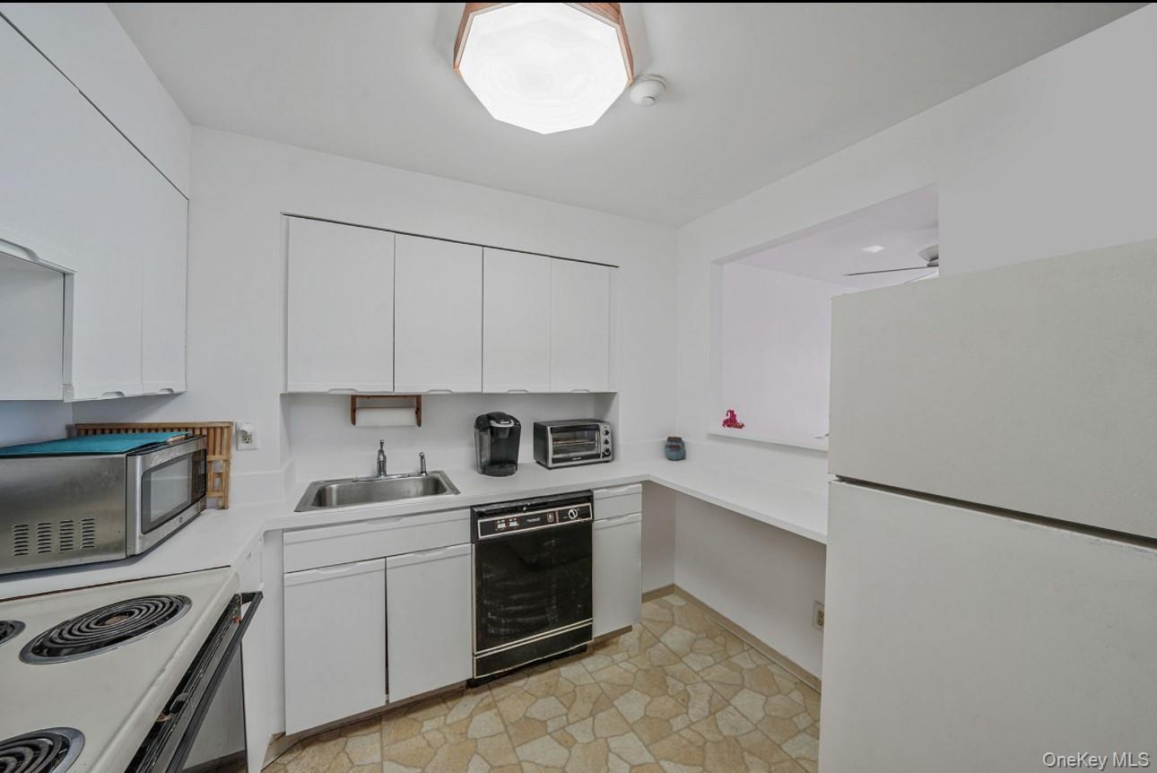 360 Shore Road, Unit 4B Long Beach, NY 11561 - Photo 13 of 28 a kitchen with white cabinets and white appliances