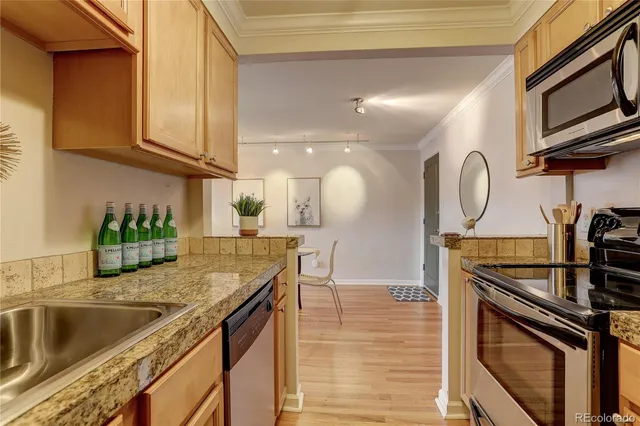 a kitchen with stainless steel appliances granite countertop a sink a stove and cabinets