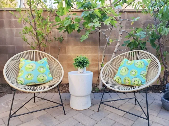 a backyard of a house with table and chairs plants