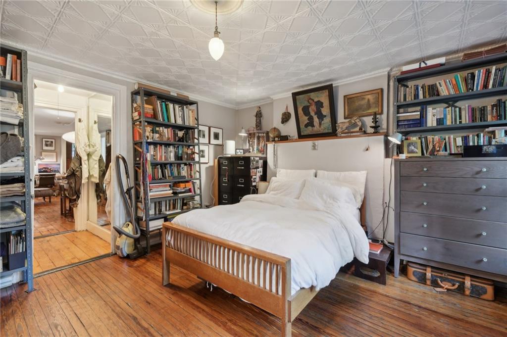 146 St James Place Brooklyn, NY 11238 - Photo 7 of 10 a bedroom with a bed and a book shelf