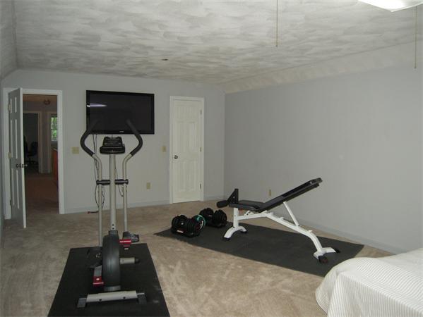 338 Robinson Road Boxborough, MA 01719 - Photo 13 of 18 a room with gym equipment and a view of living room