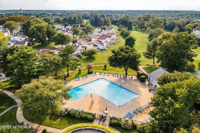 an aerial view of residential houses with outdoor space and trees