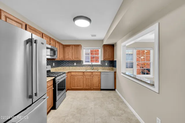 a kitchen with stainless steel appliances granite countertop a refrigerator sink and stove