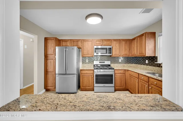 a kitchen with stainless steel appliances granite countertop a stove sink and cabinets