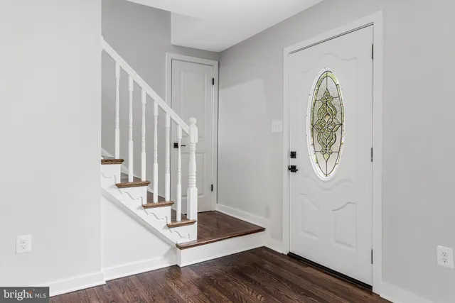a view of an empty room with wooden floor and staircase
