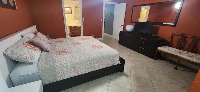a bedroom with a bed and dresser with mirror