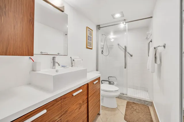 a bathroom with a sink a toilet and shower