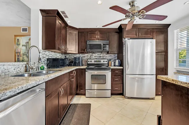a kitchen with stainless steel appliances granite countertop a stove a refrigerator and a sink