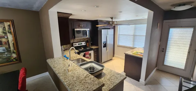 a view of a kitchen with fridge and workspace