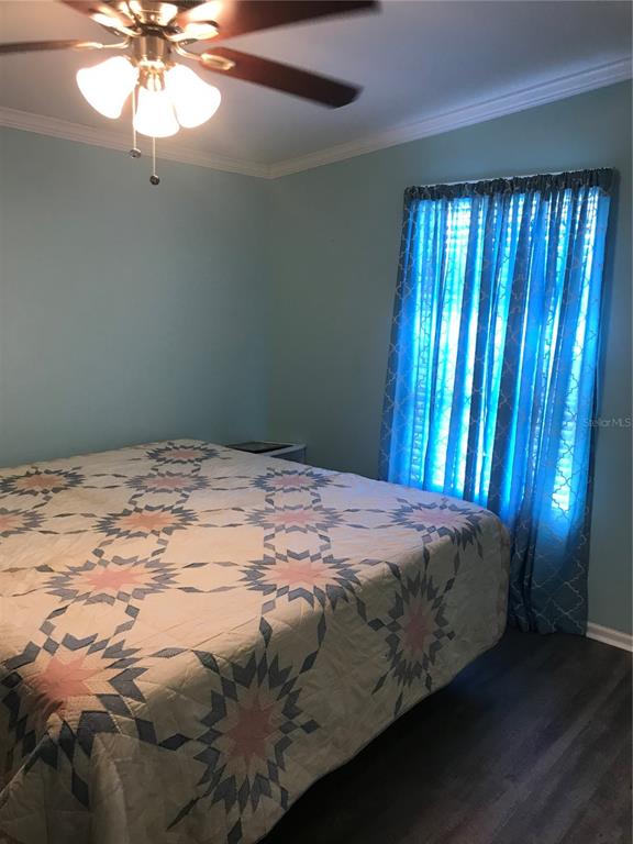 1081 6th Street Okeechobee, FL 34974 - Photo 14 of 22 a bed sitting in a bedroom next to a window and a chandelier