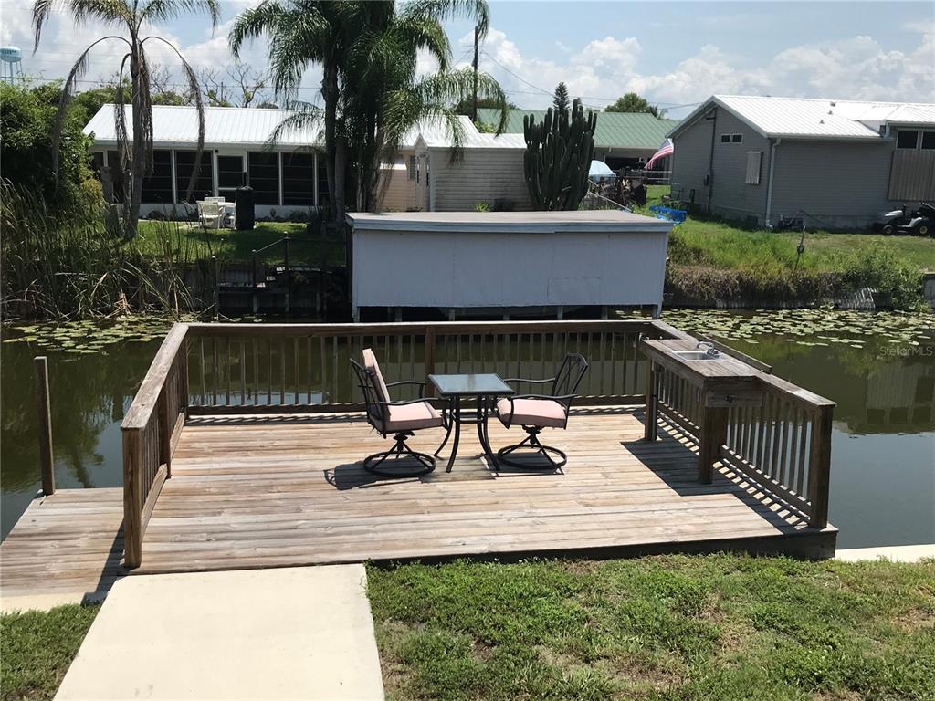 1081 6th Street Okeechobee, FL 34974 - Photo 21 of 22 a view of a patio with table and chairs with wooden fence