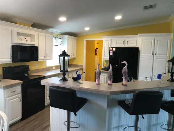 a kitchen with stainless steel appliances kitchen island granite countertop a sink and cabinets