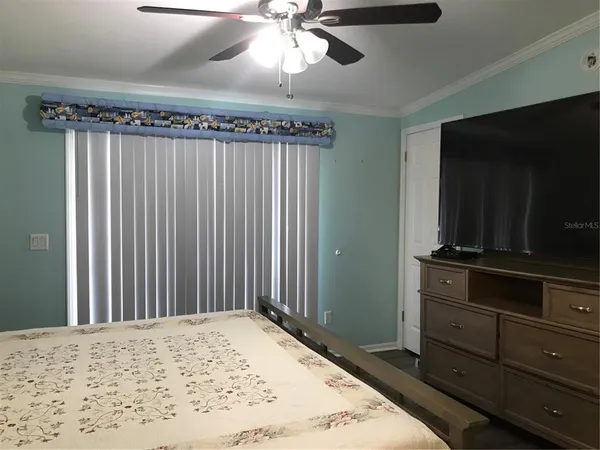 a bedroom with a bed and a flat tv screen on dresser