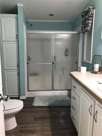 a bathroom with a double vanity sink toilet and shower