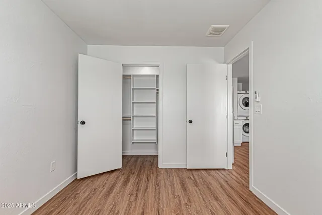 a view of empty room with wooden floor