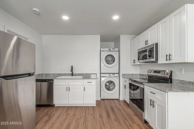 a kitchen with a refrigerator a stove top oven and wooden floor