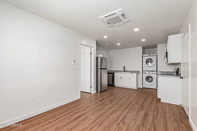 a view of a kitchen with a refrigerator and wooden floor