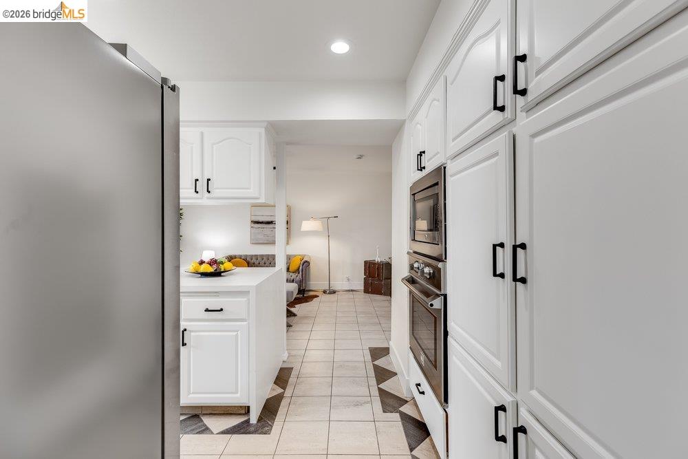 1298 Ribbon Street Foster City, CA 94404 - Photo 33 of 86 White cabinetry with black hardware, built-in stainless steel appliances, and checkerboard floor tiling