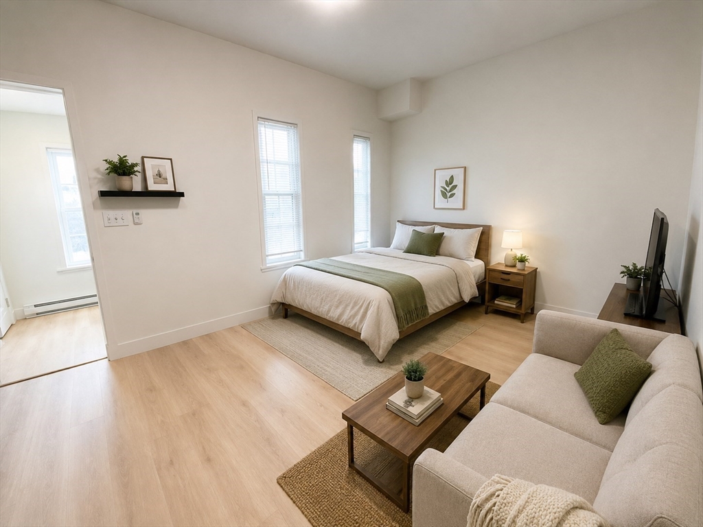 568 Main Street, Unit 3 Woburn, MA 01801 - Photo 1 of 8 a bedroom with two beds and a couch