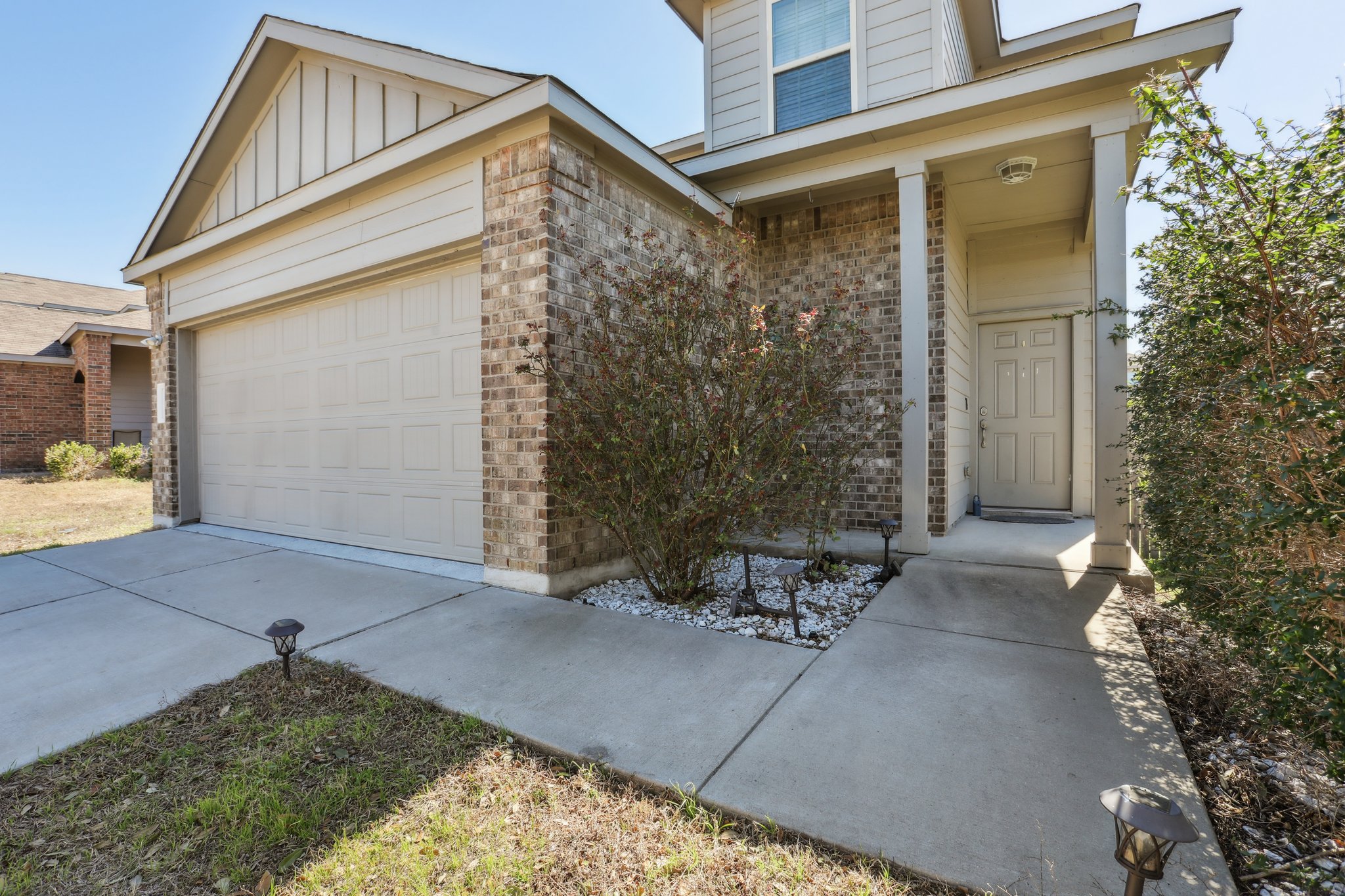 5713 Kennedy Street Austin, TX 78747 - Photo 1 of 30 View of exterior entry featuring brick siding, board and batten siding, concrete driveway, and a garage