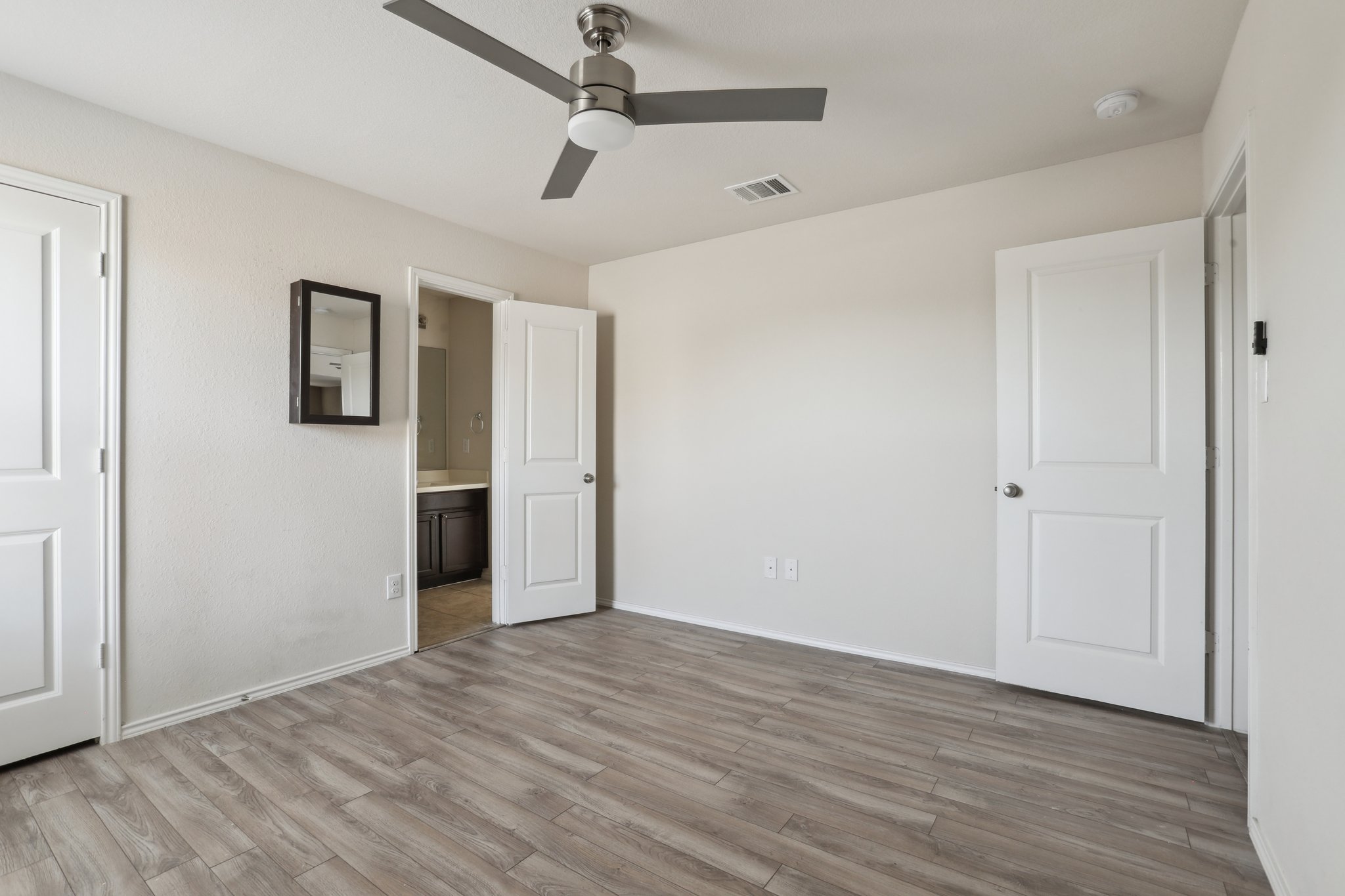 5713 Kennedy Street Austin, TX 78747 - Photo 19 of 30 Unfurnished bedroom with wood finished floors, a ceiling fan, and ensuite bathroom