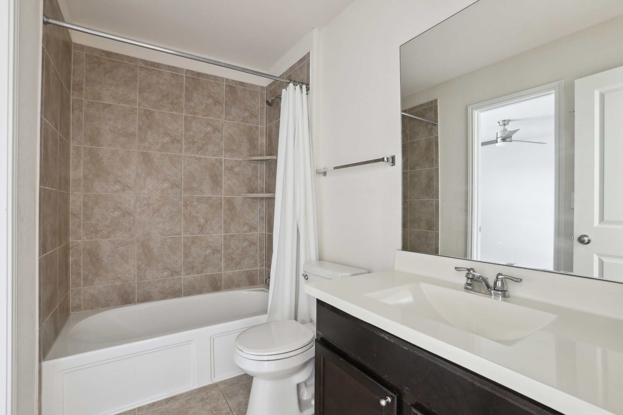 5713 Kennedy Street Austin, TX 78747 - Photo 21 of 30 Bathroom featuring vanity, shower / tub combo with curtain, and light tile patterned floors