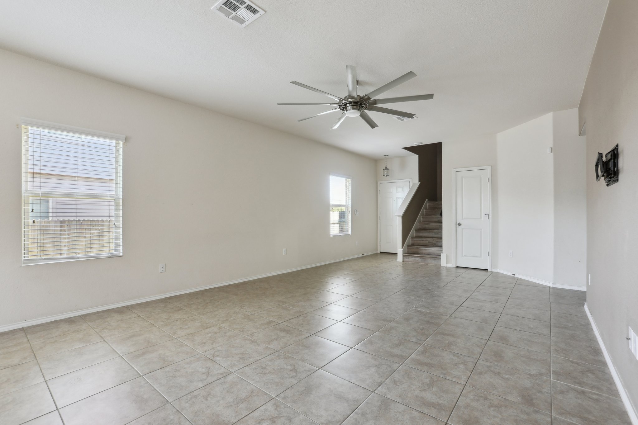 5713 Kennedy Street Austin, TX 78747 - Photo 7 of 30 Empty room with a ceiling fan and light tile patterned floors