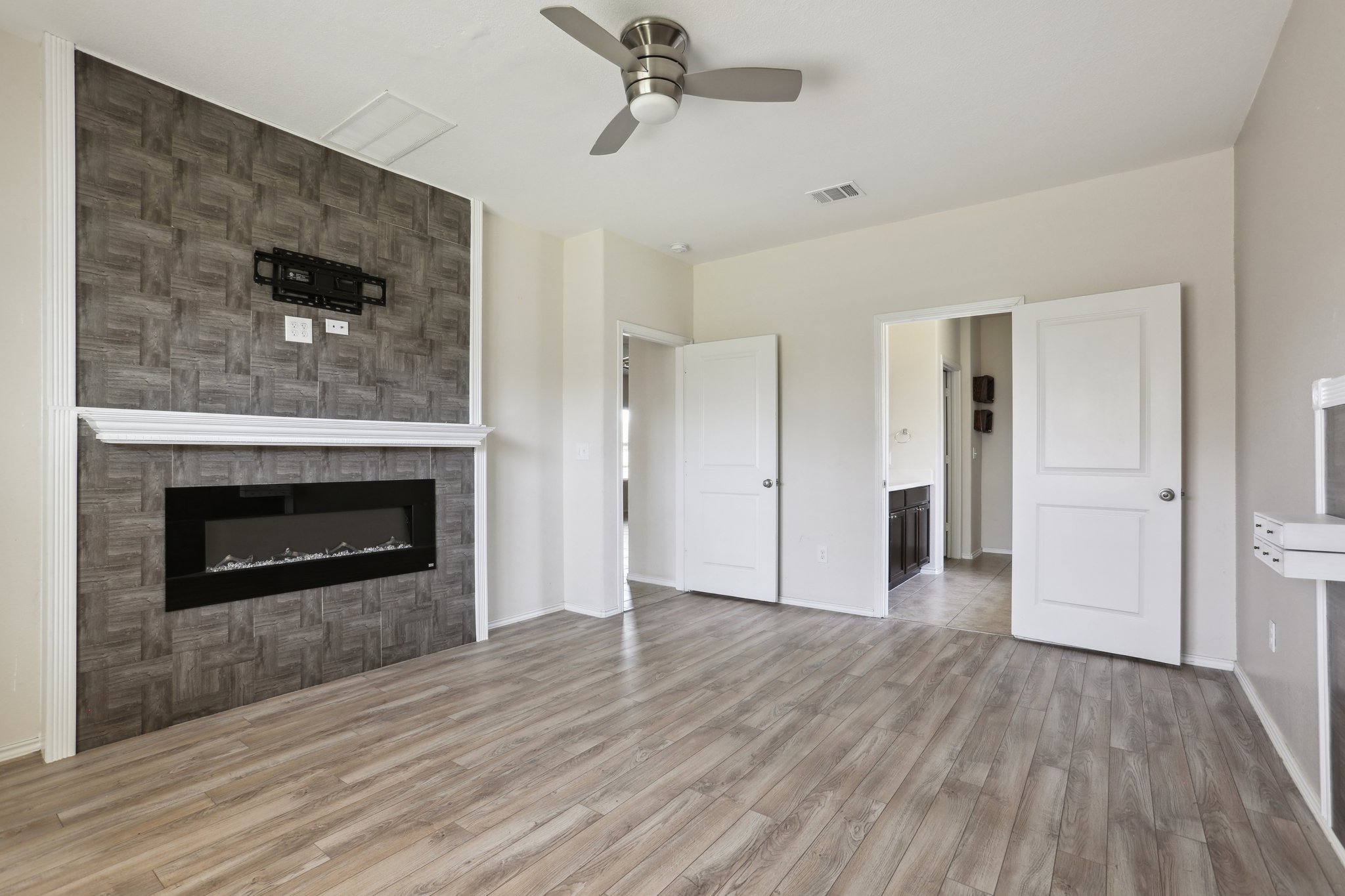 5713 Kennedy Street Austin, TX 78747 - Photo 8 of 30 Unfurnished living room featuring light wood-style flooring, ceiling fan, and a fireplace