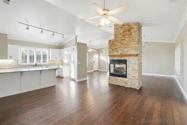 a view of a kitchen with furniture a fireplace and wooden floor