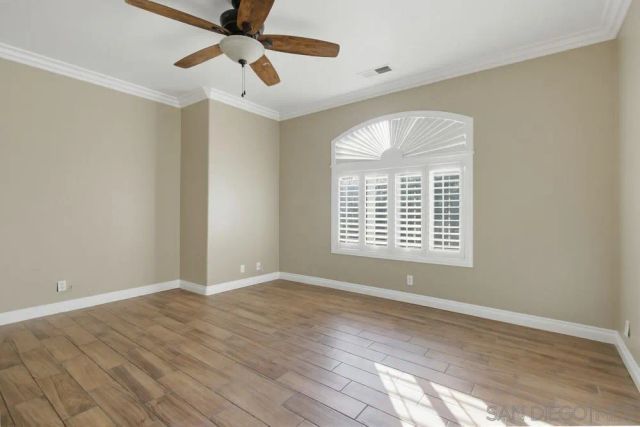 a view of an empty room with a window and a ceiling fan