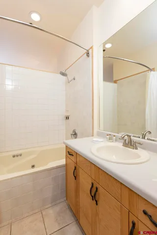 a bathroom with a granite countertop sink mirror and a bathtub
