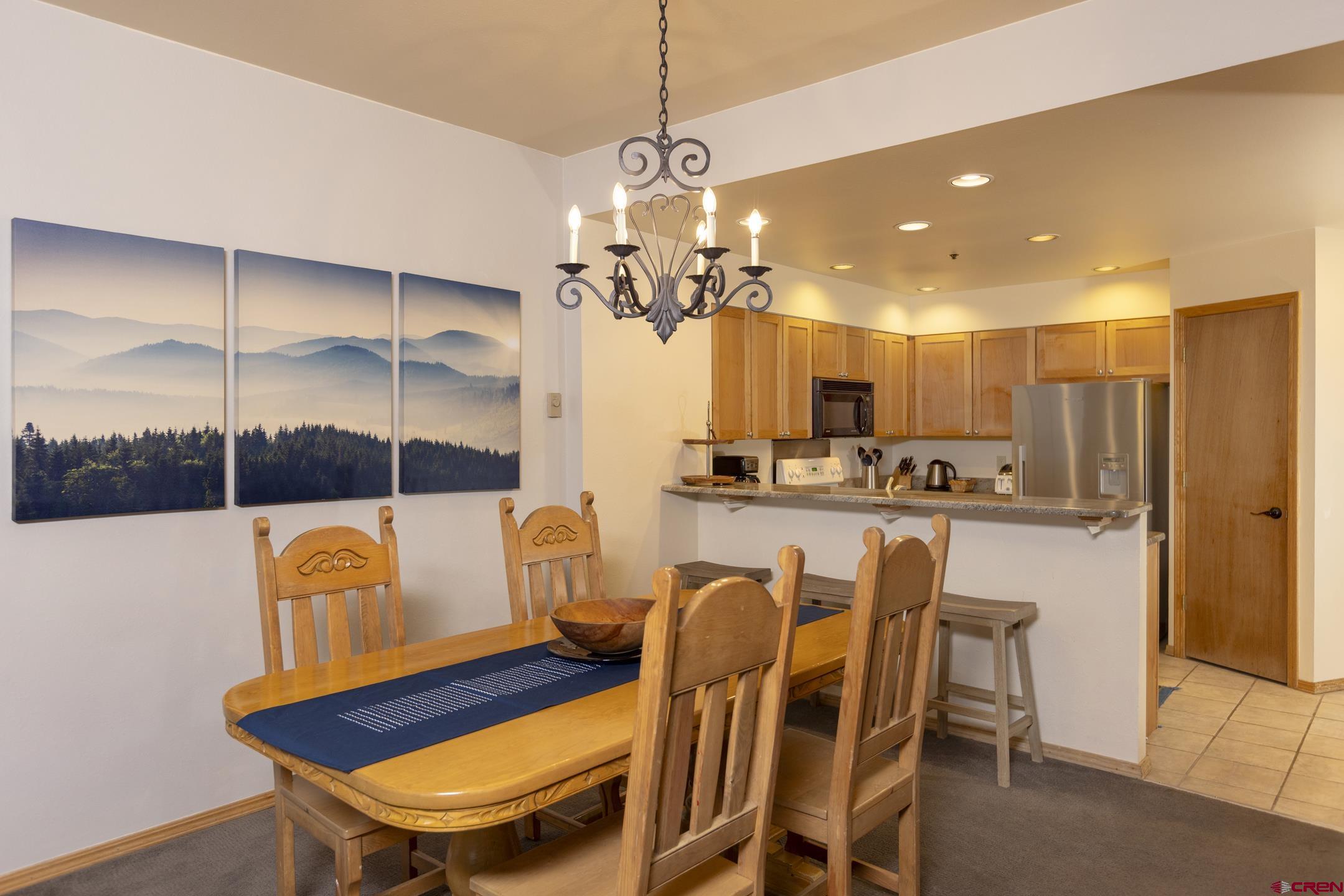 71 Needles Way, Unit 541 Durango, CO 81301 - Photo 6 of 32 a dining room filled chandelier and kitchen view