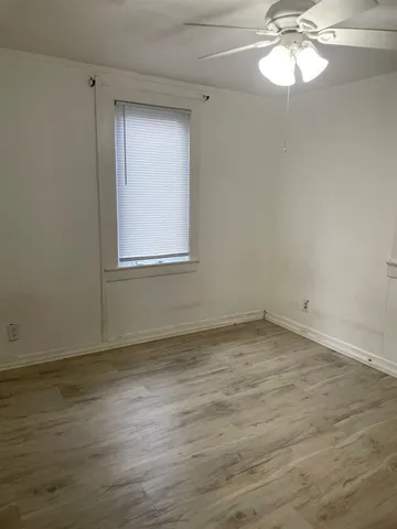 a view of a room with wooden floor and a window