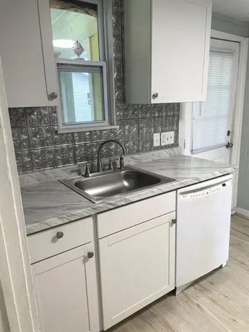 a view with granite countertop a sink and cabinets